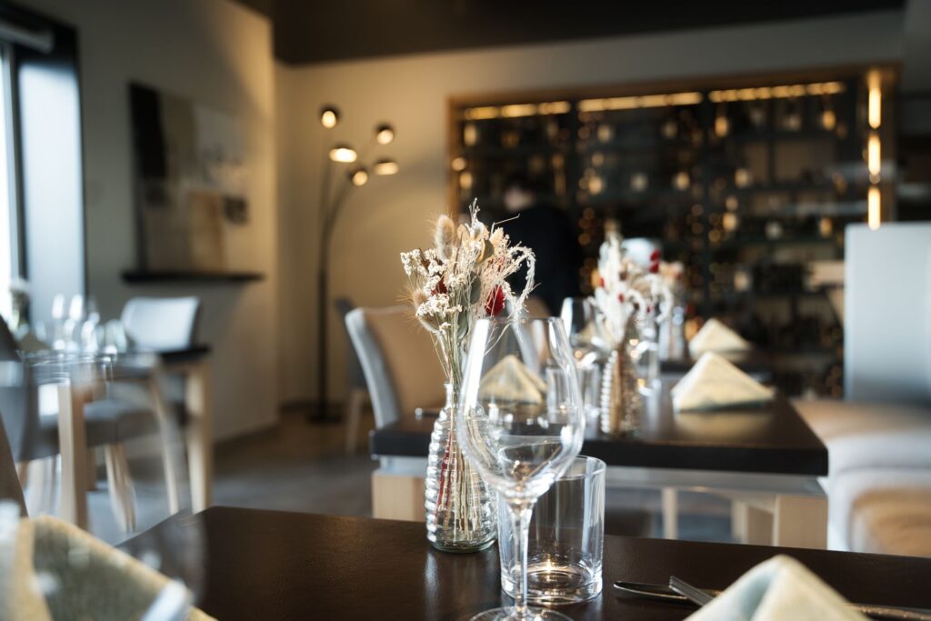 Table dressée avec la cave à vin en fond restaurant ala12