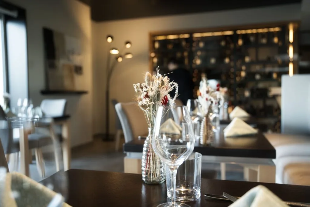 Table dressée avec la cave à vin en fond restaurant ala12